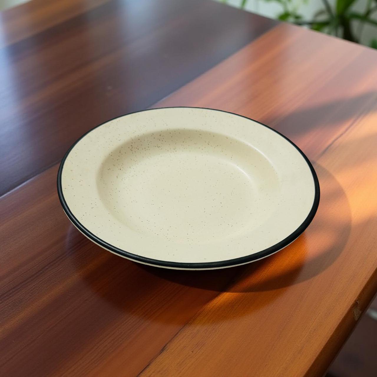 Beige ceramic plate with black rim on a wooden table