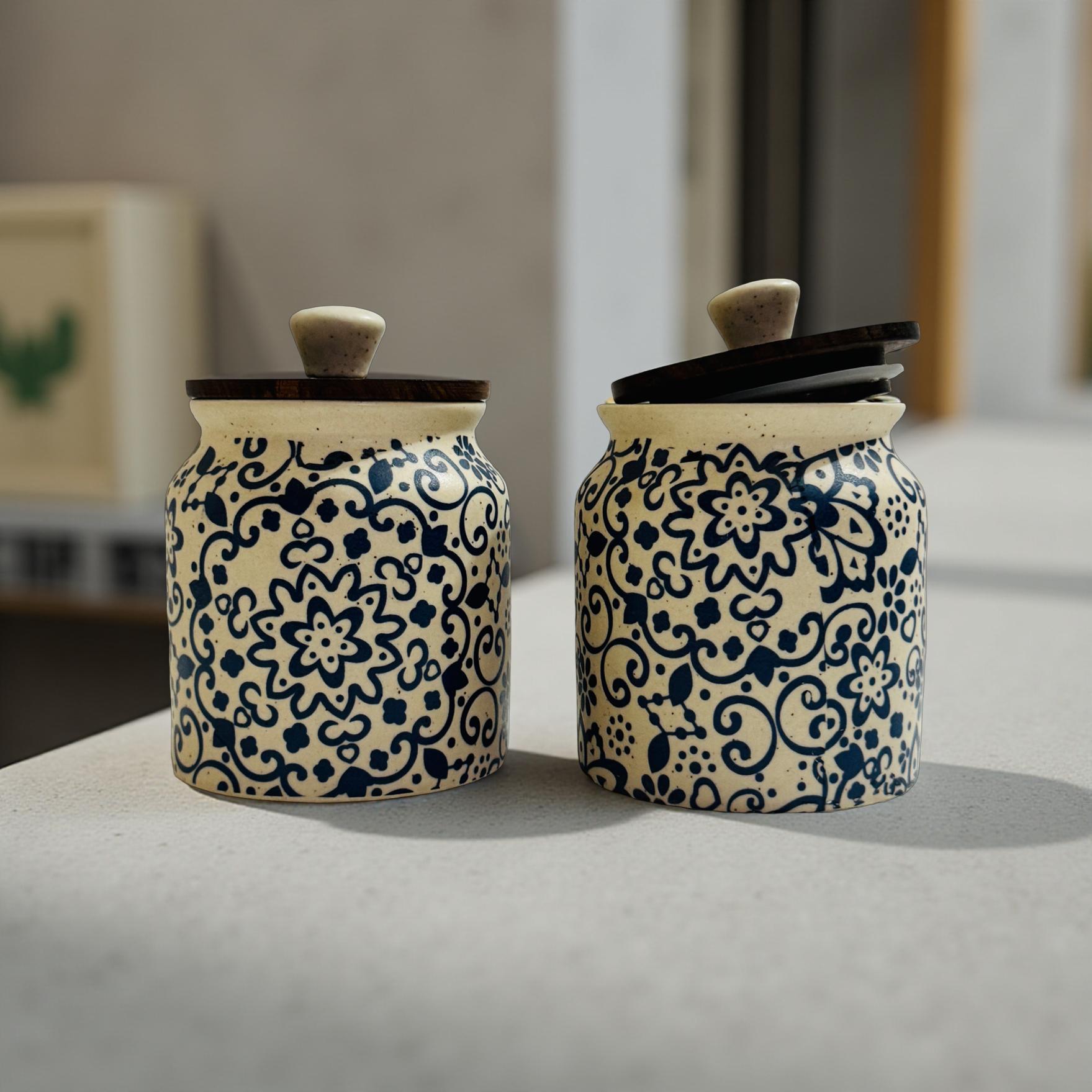 Set of two handcrafted navy blue indigo patterned ceramic jars with wooden lids on a light counter