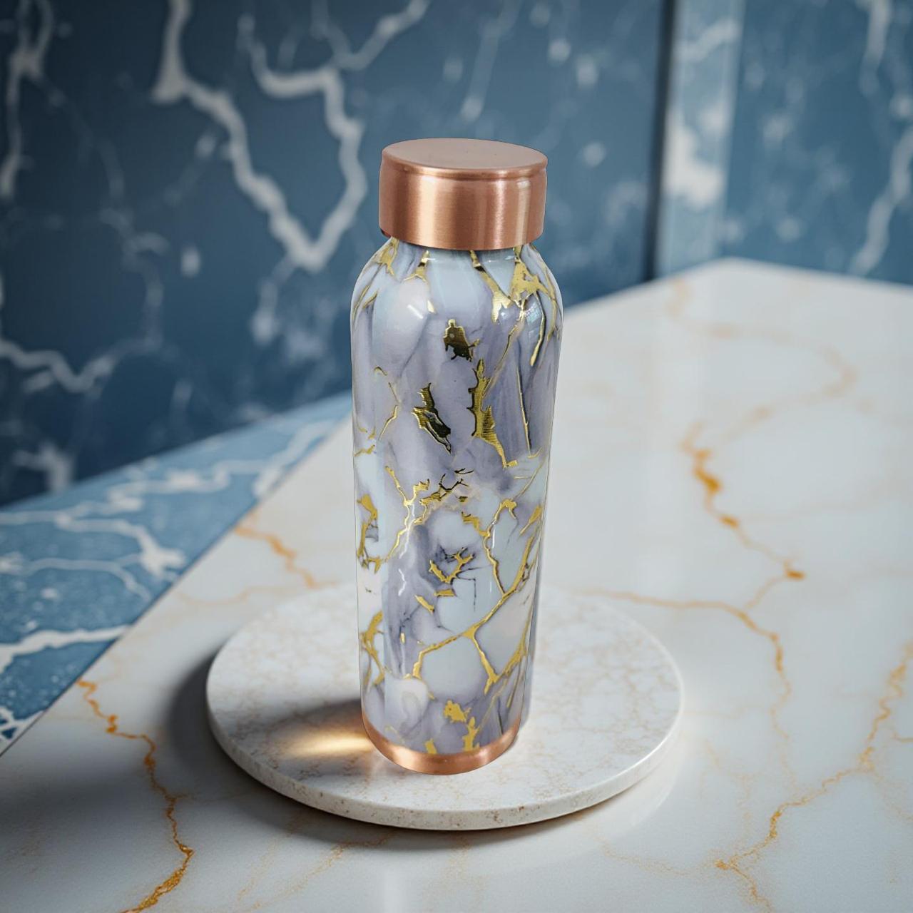 Marble-patterned water bottle with rose gold cap on a marble surface