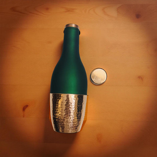 Green bottle with metallic base on a wooden surface