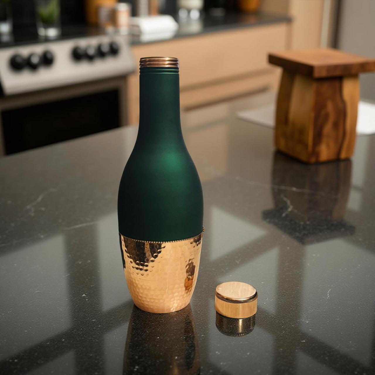 Decorative bottle with green top and gold bottom on a kitchen counter
