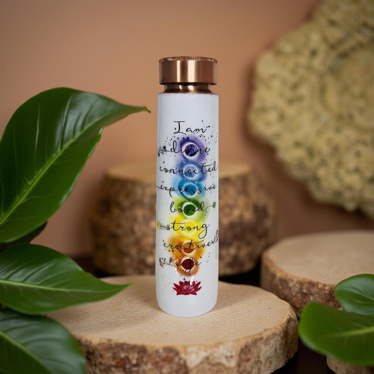 White water bottle with colorful designs and text on a wooden surface with leaves.