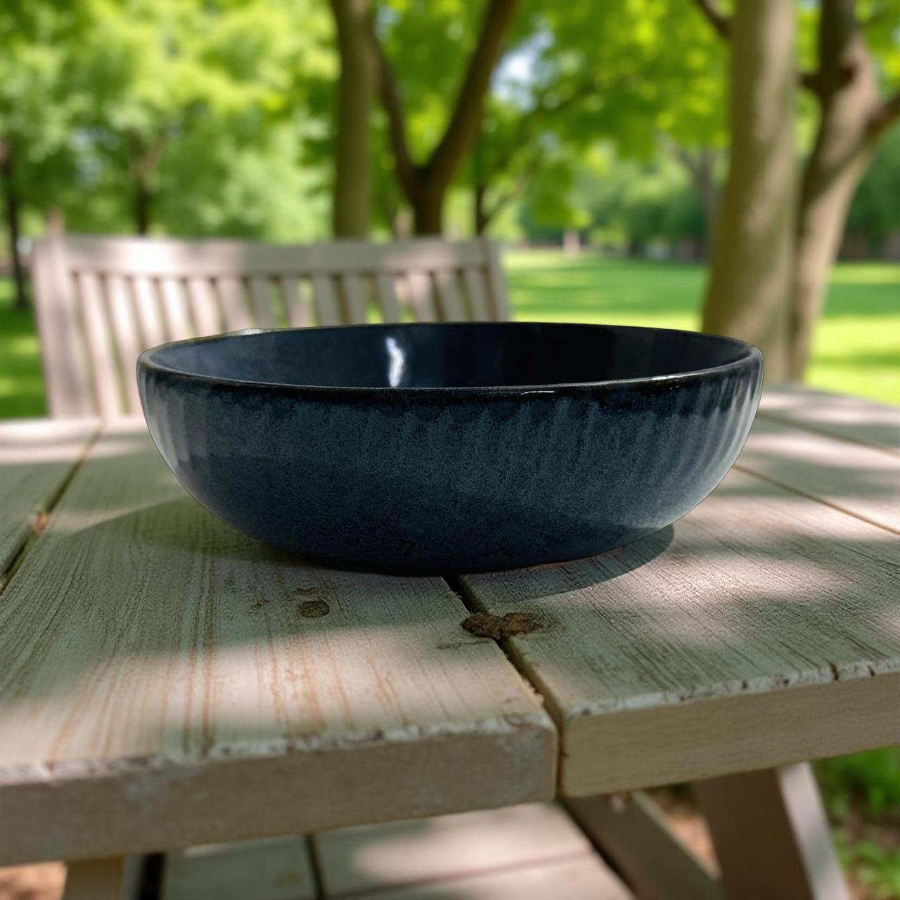 Black bowl on a wooden table with a park background