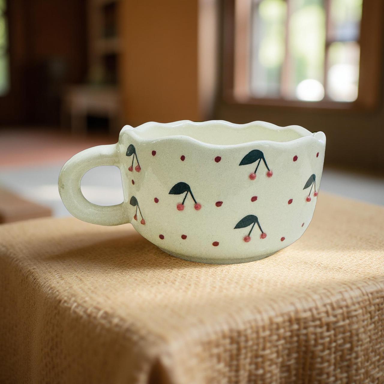 Ceramic mug with cherry design on a textured surface