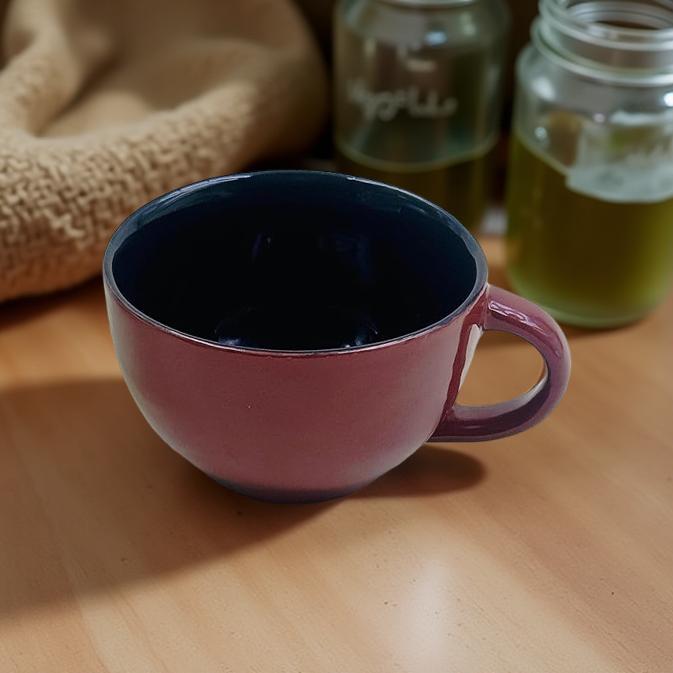 Pink mug on a wooden surface with jars in the background