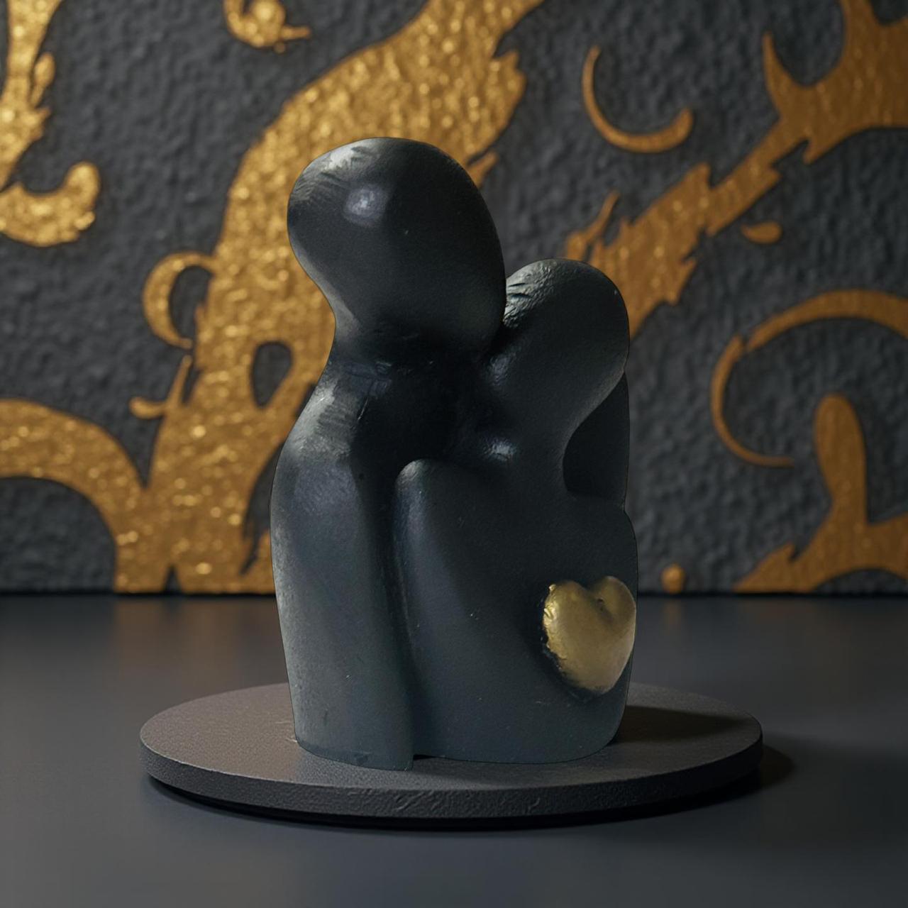 Black figurine with a gold heart on a dark surface with a decorative background