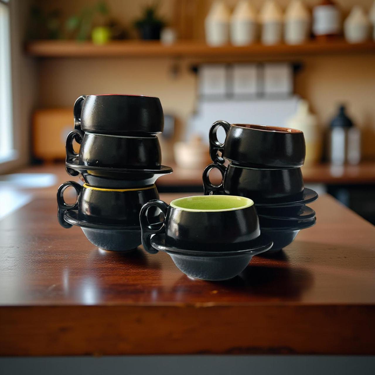 Set of black ceramic cups and saucers on a wooden surface with a blurred background