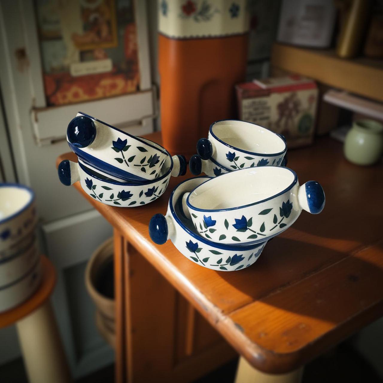 Set of ceramic bowls with blue floral patterns on a wooden surface.