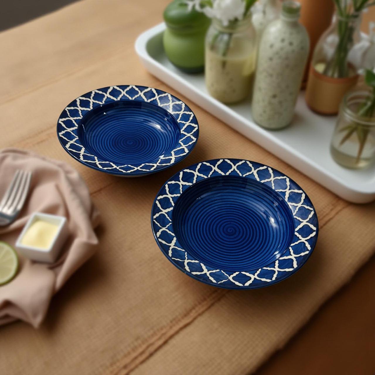 Two blue ceramic plates with white patterns on a wooden table.