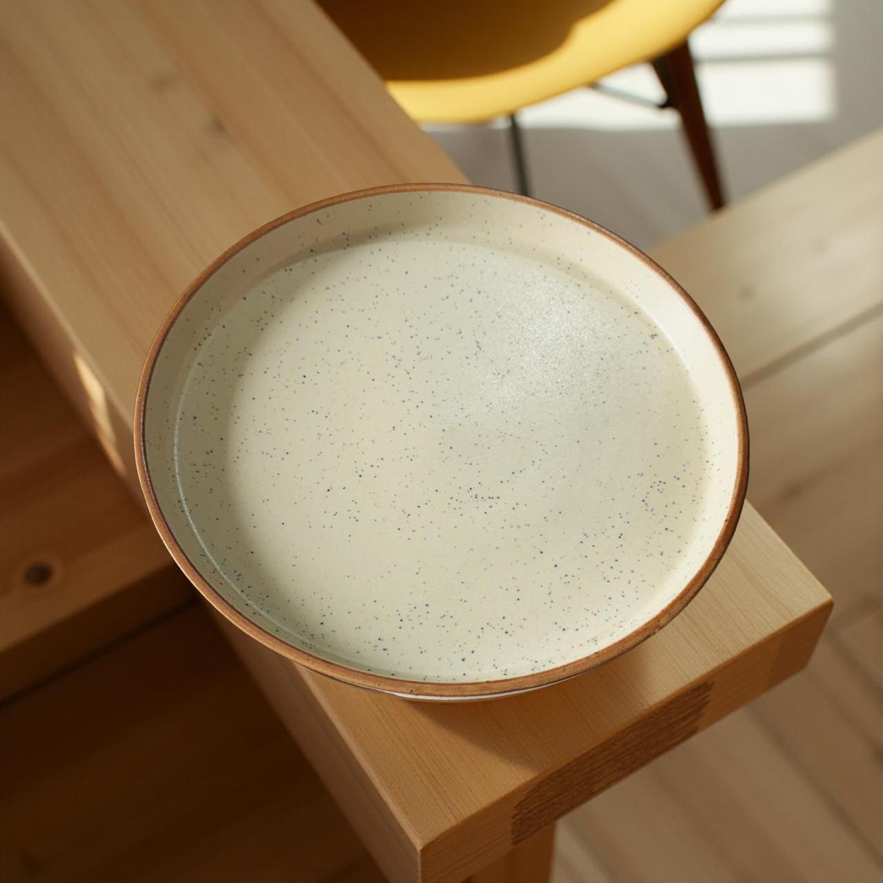 Ceramic bowl with speckled texture on a wooden surface