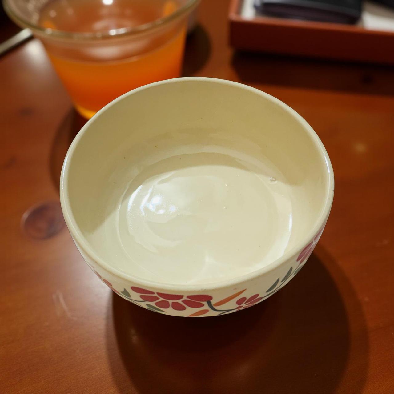 Small ceramic bowl with floral design on a wooden surface