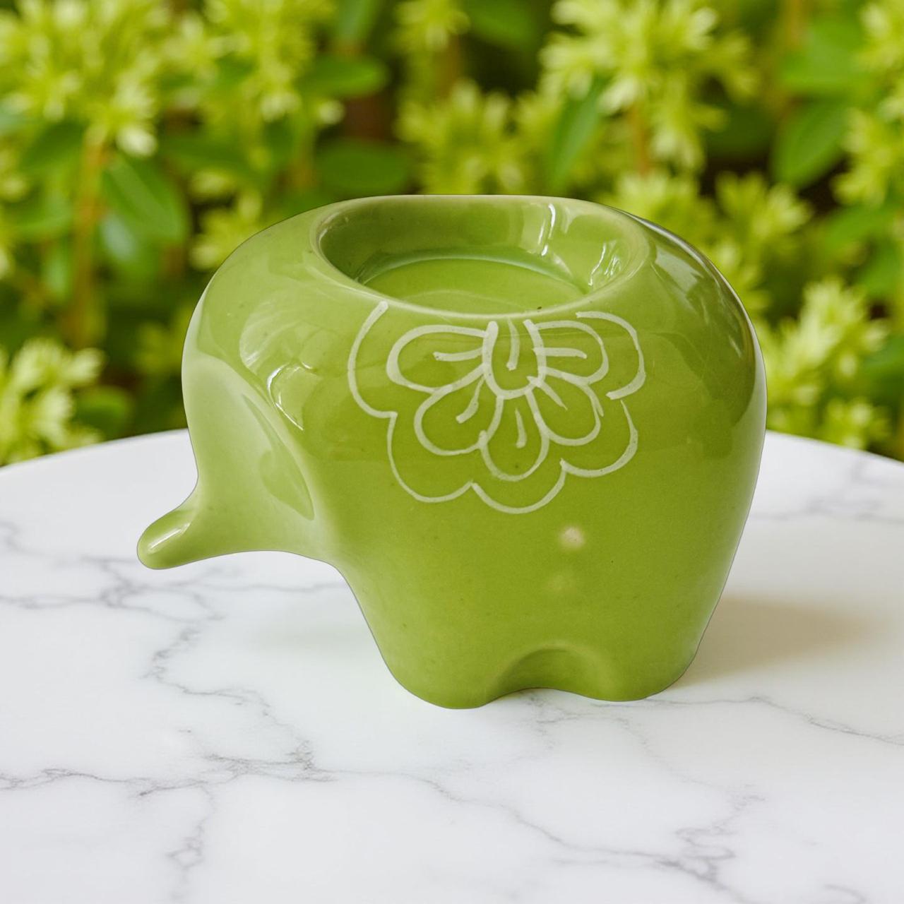 light green baby elephant t light holder in a beuatiful background