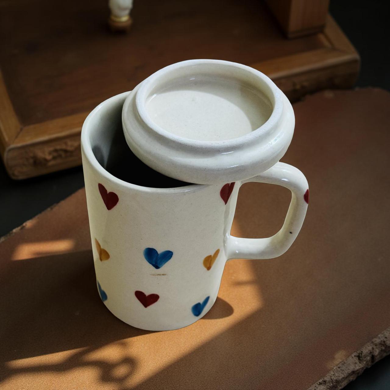 White mug with colorful heart patterns filled with a dark liquid, placed on a wooden surface.