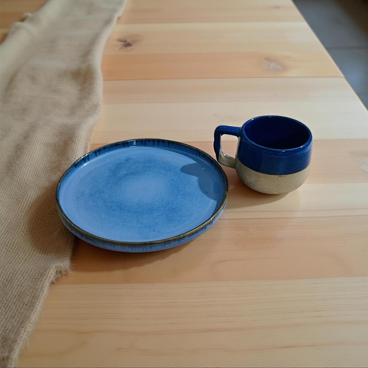 Blue ceramic plate and mug on a wooden surface