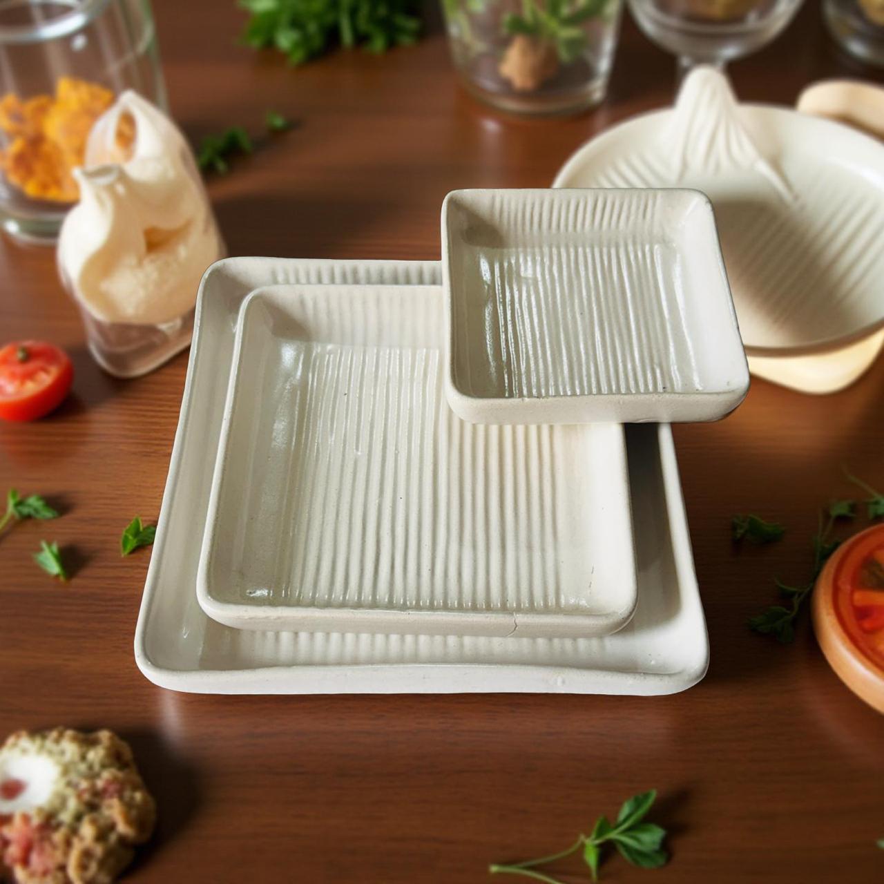 Set of white ceramic dishes on a wooden surface with vegetables in the background