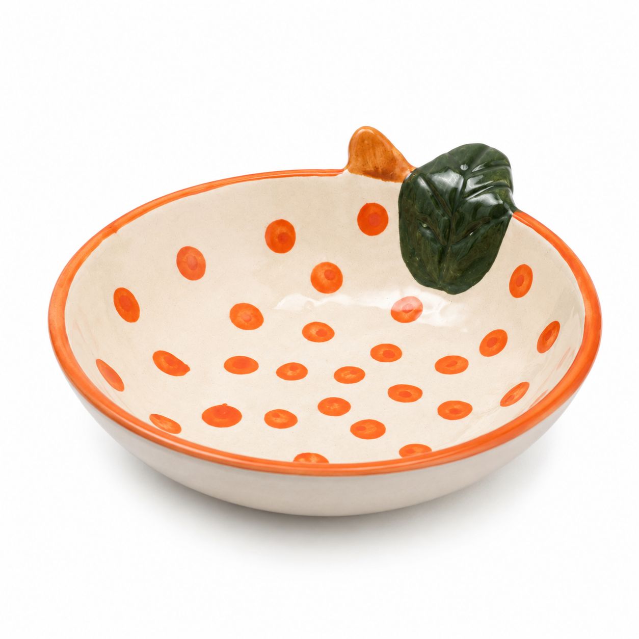Ceramic bowl shaped like a pumpkin with orange polka dots on a white background