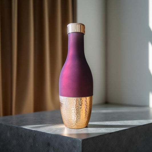 Bottle with purple and gold design on a marble surface