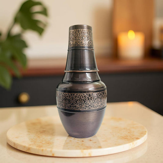 Decorative copper pot with intricate patterns on a marble surface