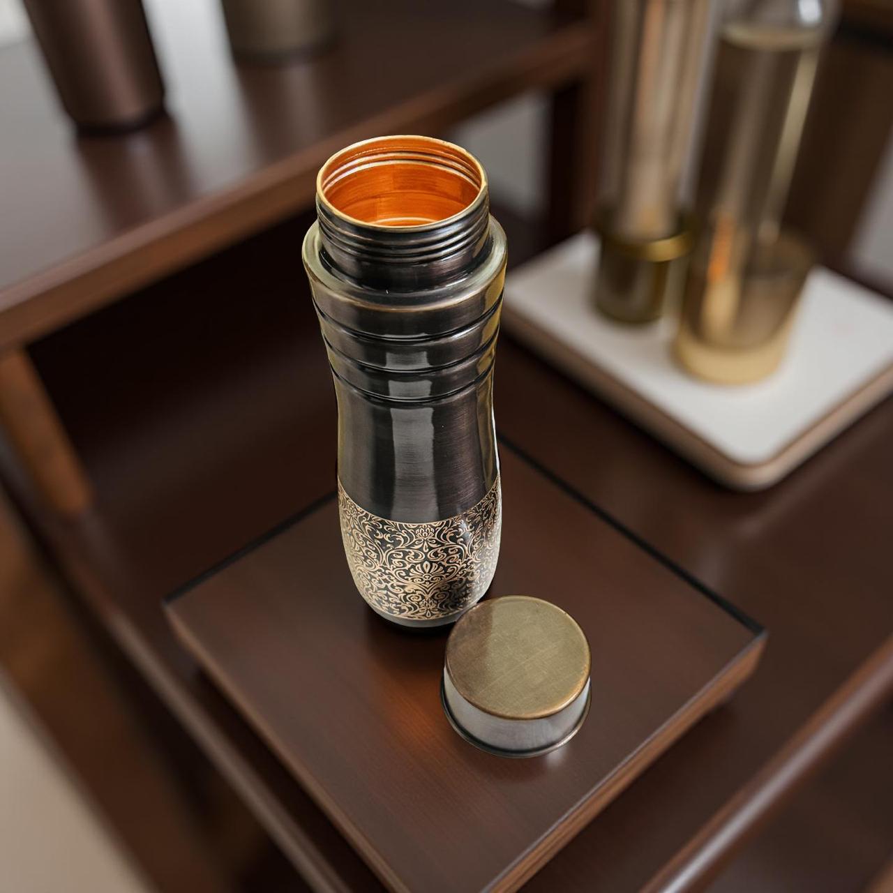 Metallic bottle with a gold cap on a wooden surface