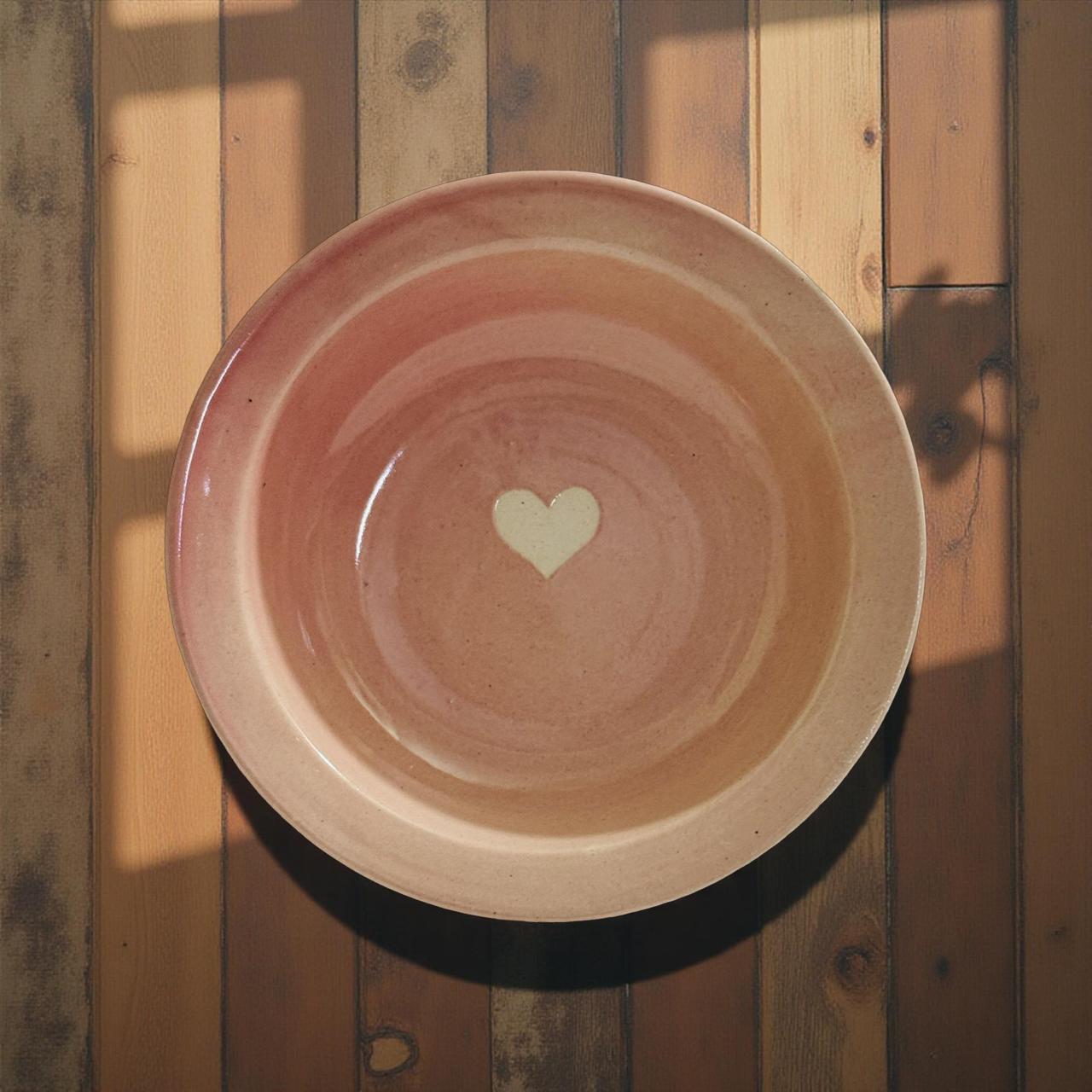 Ceramic plate with a heart design on a wooden surface