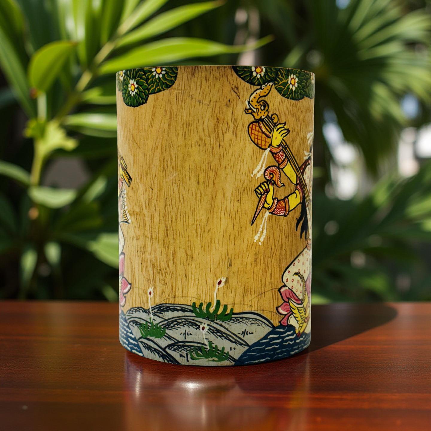 Decorative art object with artistic design on a wooden surface with plants in the background