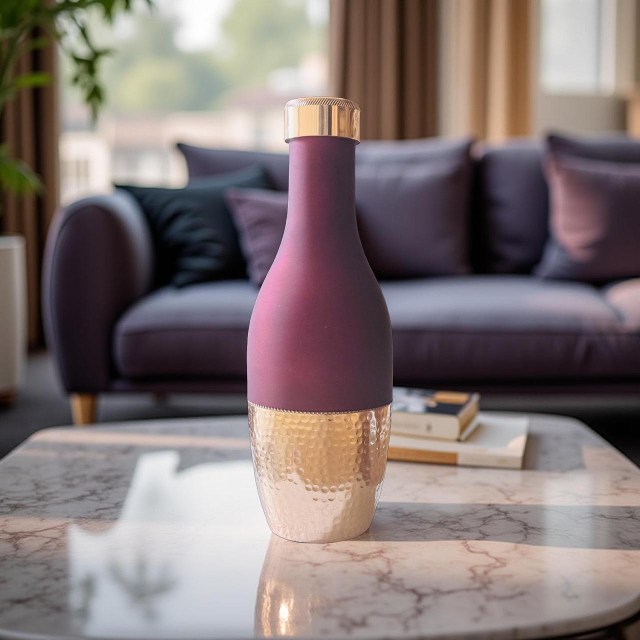 Decorative bottle with purple and gold design on a marble table in a living room.