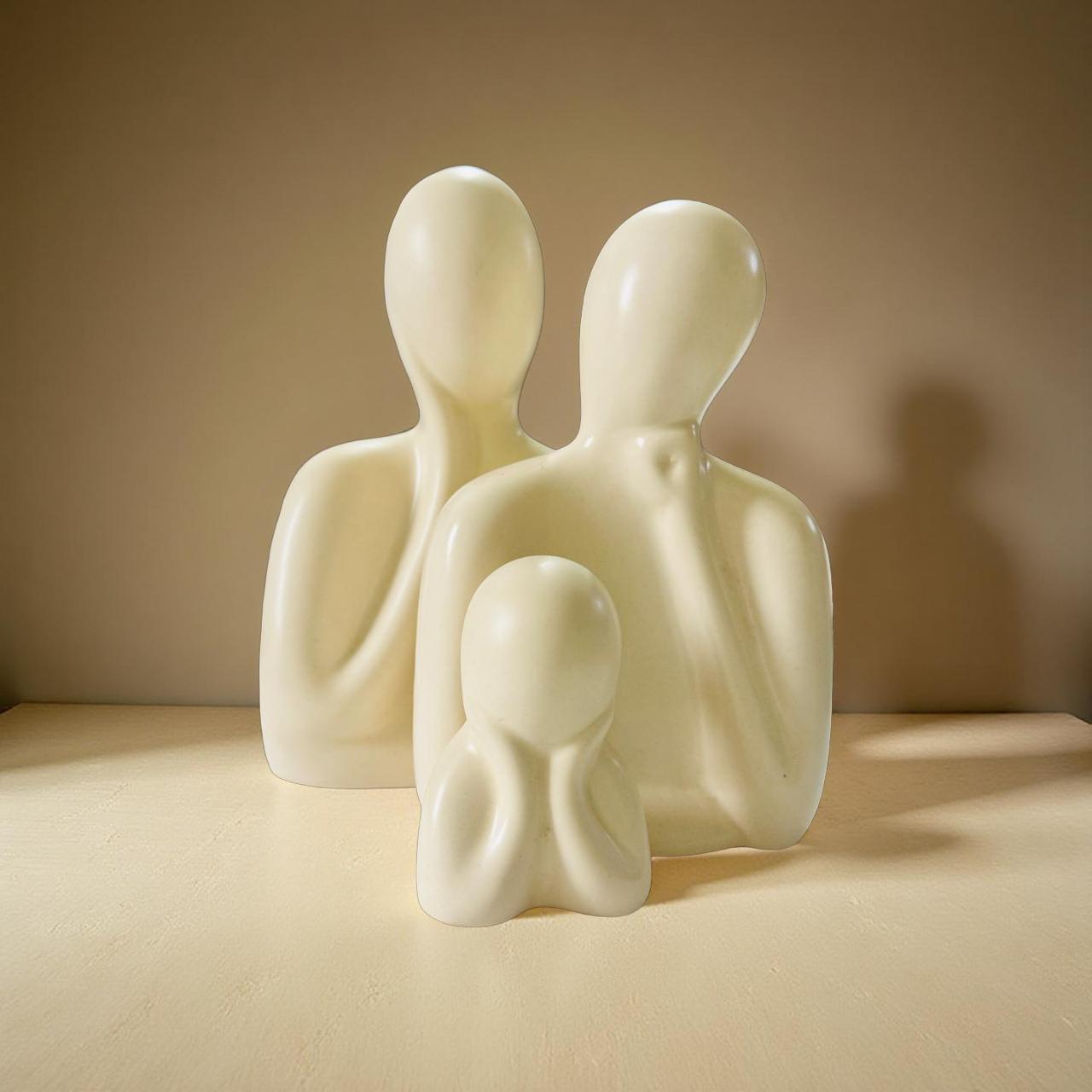 White ceramic family figurine on a beige surface with a neutral background