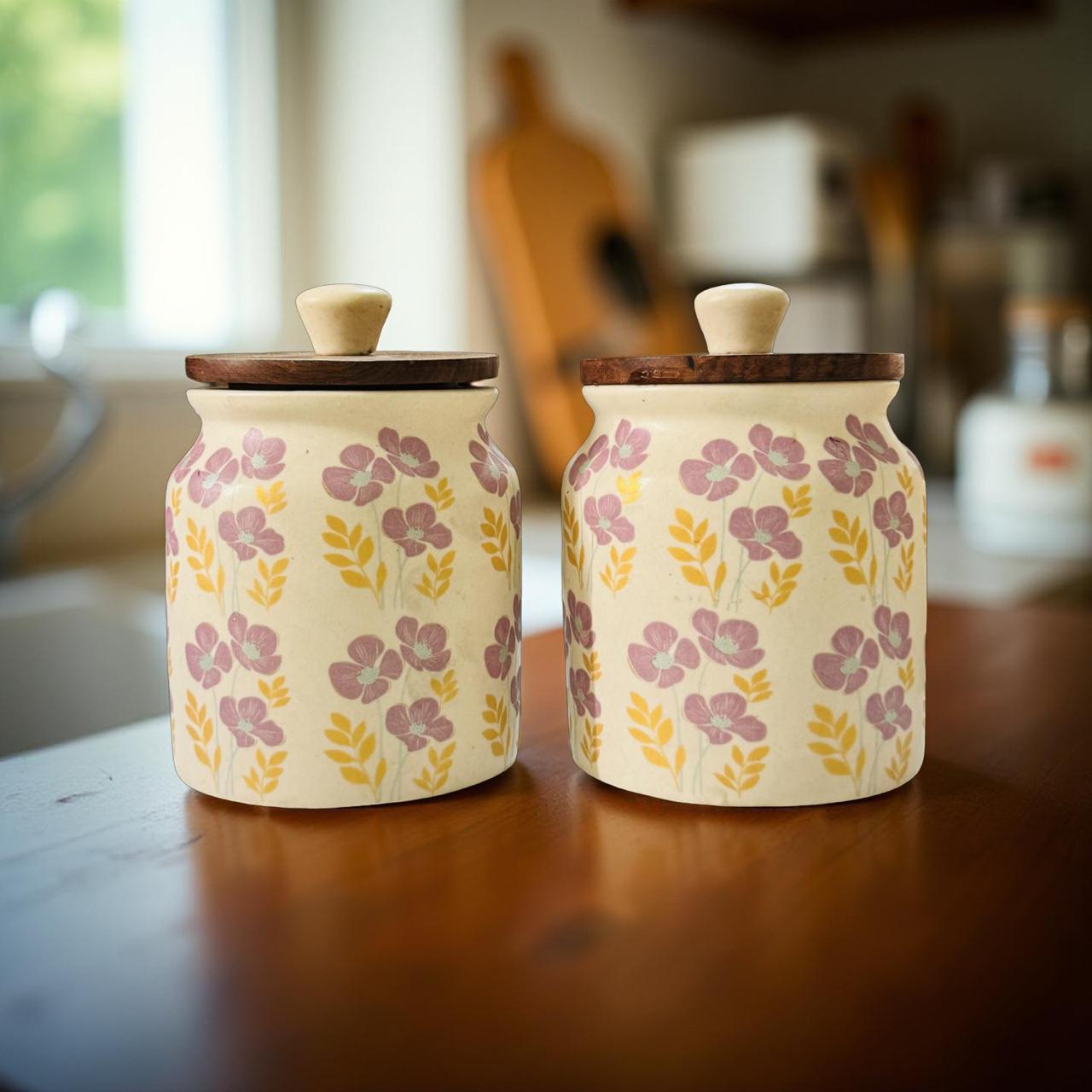 Two ceramic jars with floral patterns on a wooden surface