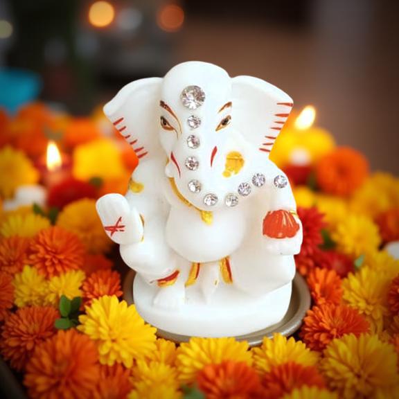 Decorative elephant figure with rhinestones on a bed of flowers and candles