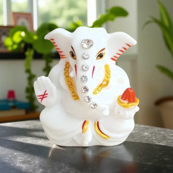 Decorative statue of ganesh idol figure with white, gold, and red colors on a reflective surface.