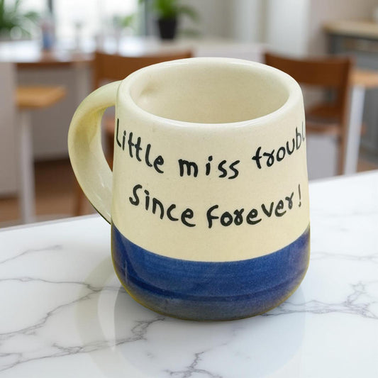 Mug with text 'Little miss trouble Since forever!' on a marble surface