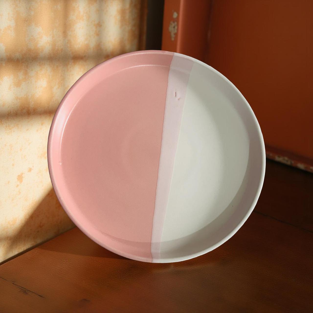 Two-tone pink and white plate on a wooden surface