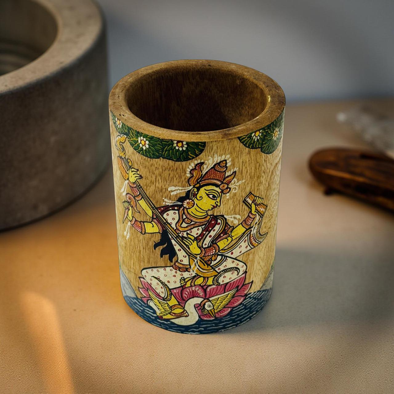 Wooden cup with artistic depiction of a figure on a neutral background