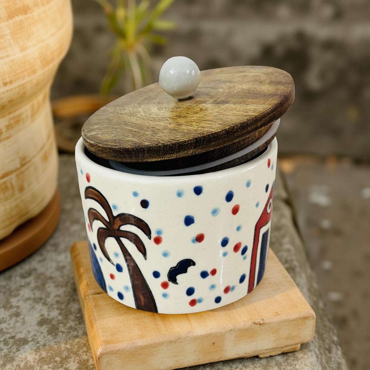 Ceramic jar with wooden lid featuring colorful polka dot pattern and cartoon design on a stone surface.