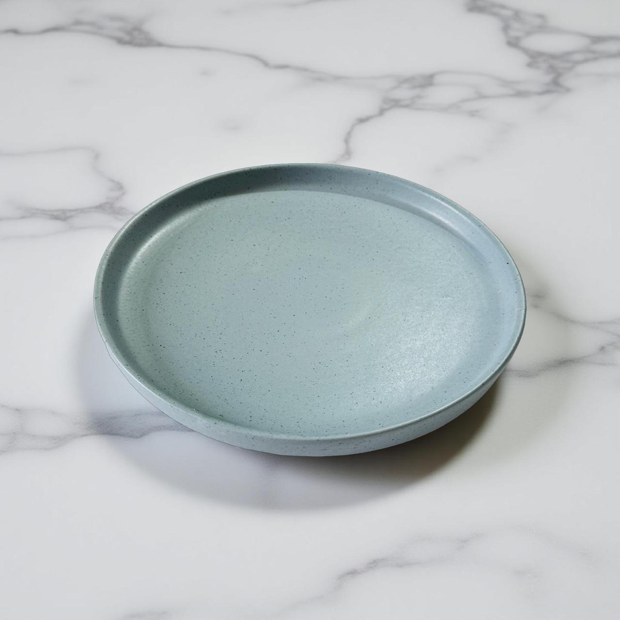 Light blue ceramic plate on a marble surface
