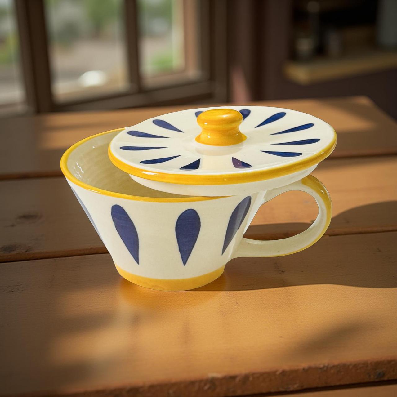 Ceramic mug with decorative lid on a wooden surface