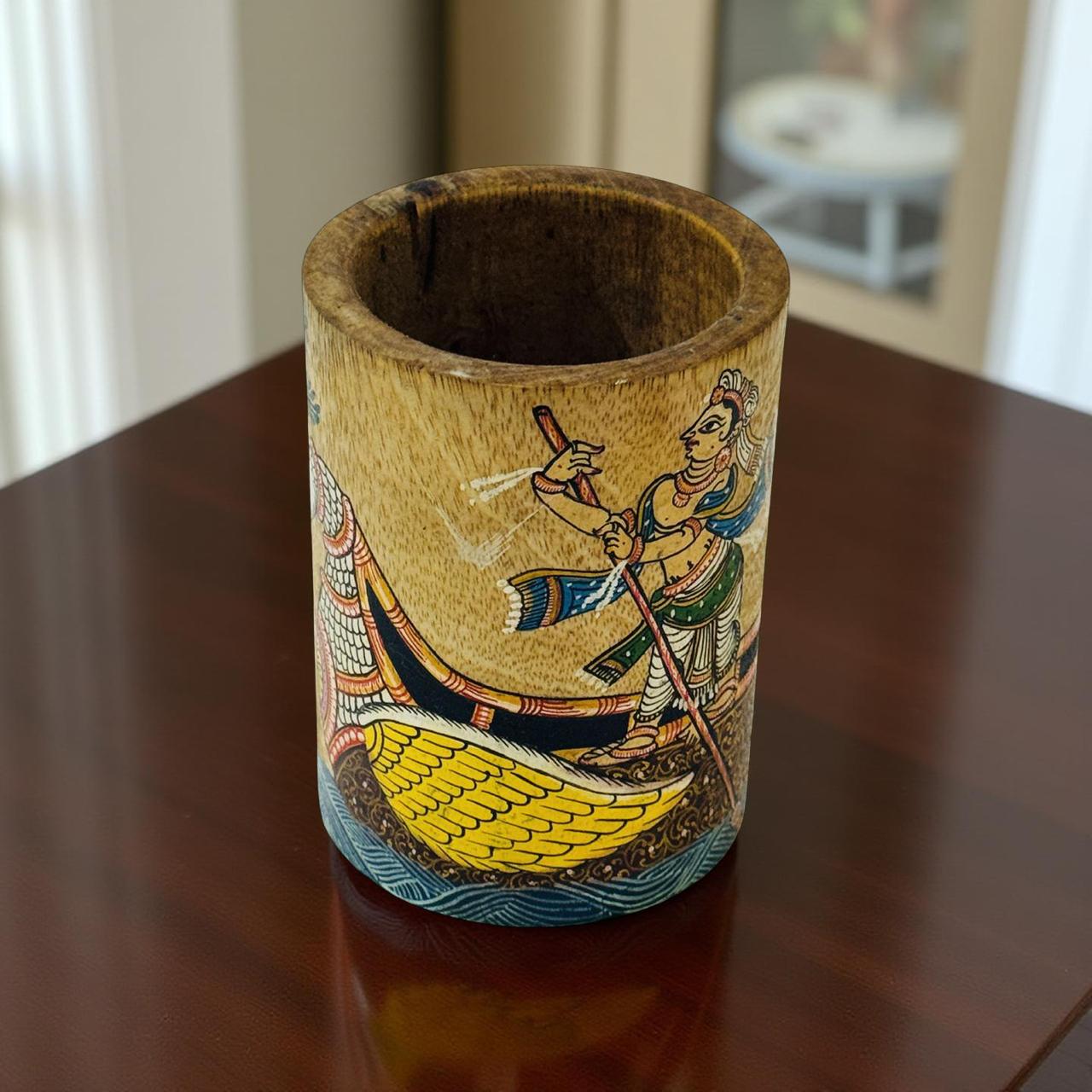Decorative wooden jar with artistic design on a reflective surface