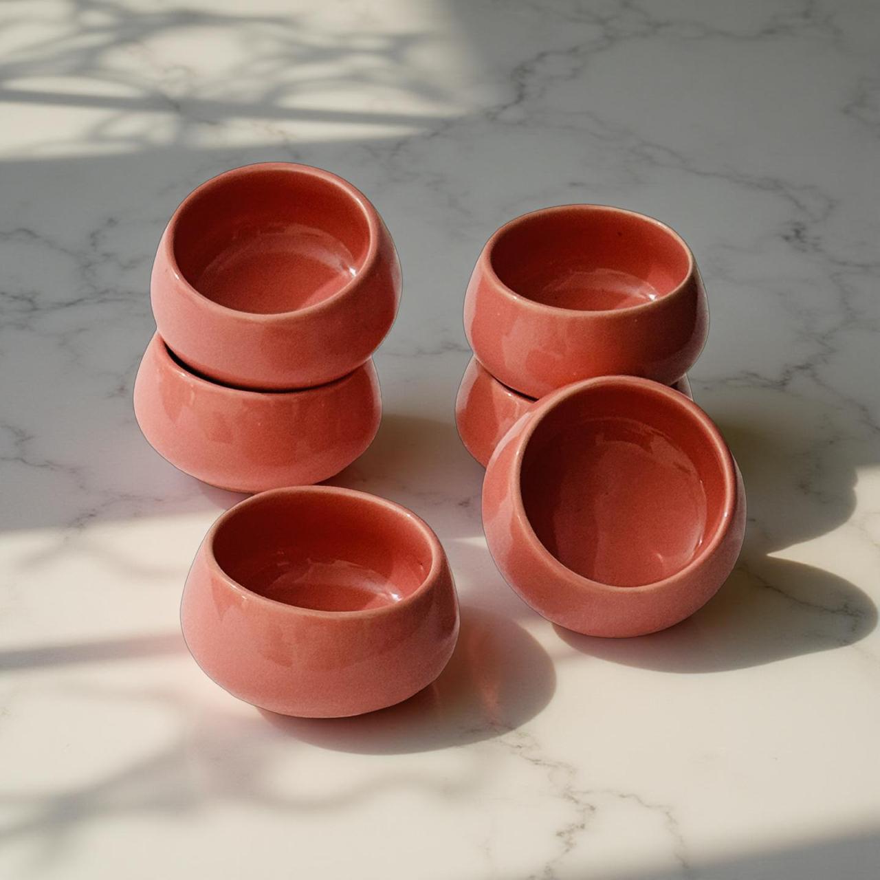 Set of five terracotta bowls on a marble surface