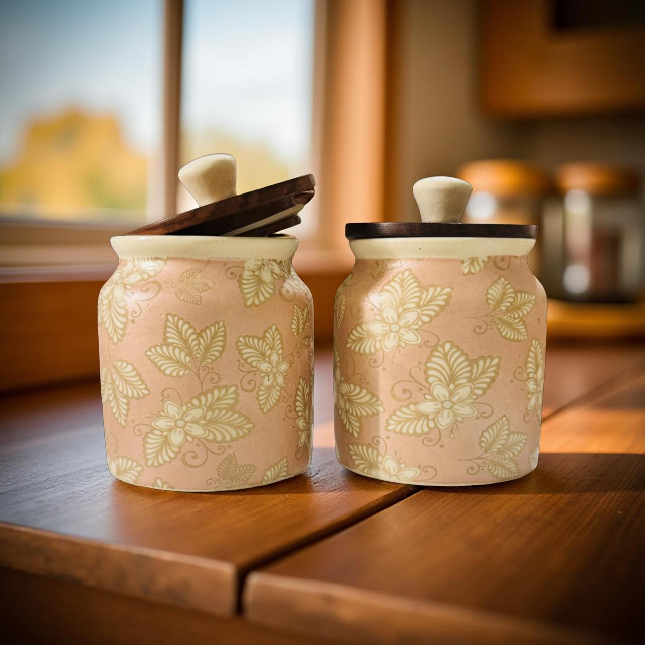 Two ceramic jars with floral patterns on a wooden surface.