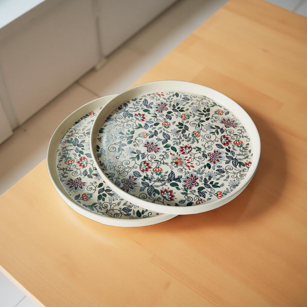 Two floral-patterned plates stacked on a wooden surface