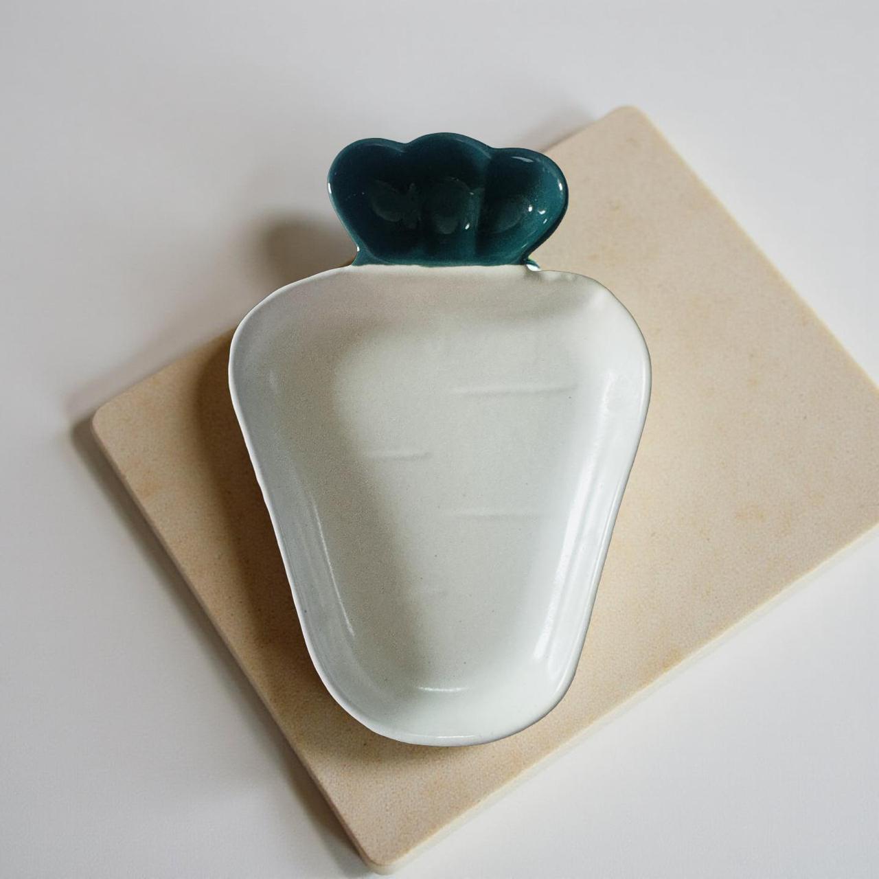Ceramic dish shaped like a green apple on a beige surface