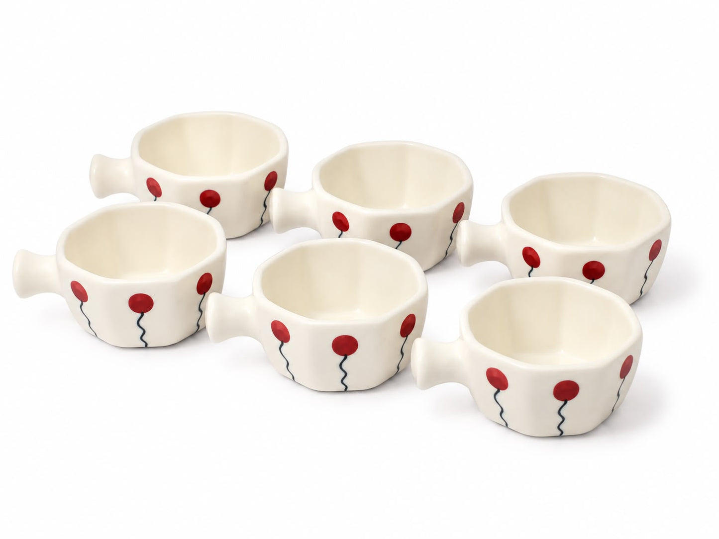 Six small white ceramic cups with handles, decorated with red balloon motifs and thin black wavy lines, arranged on a white background.