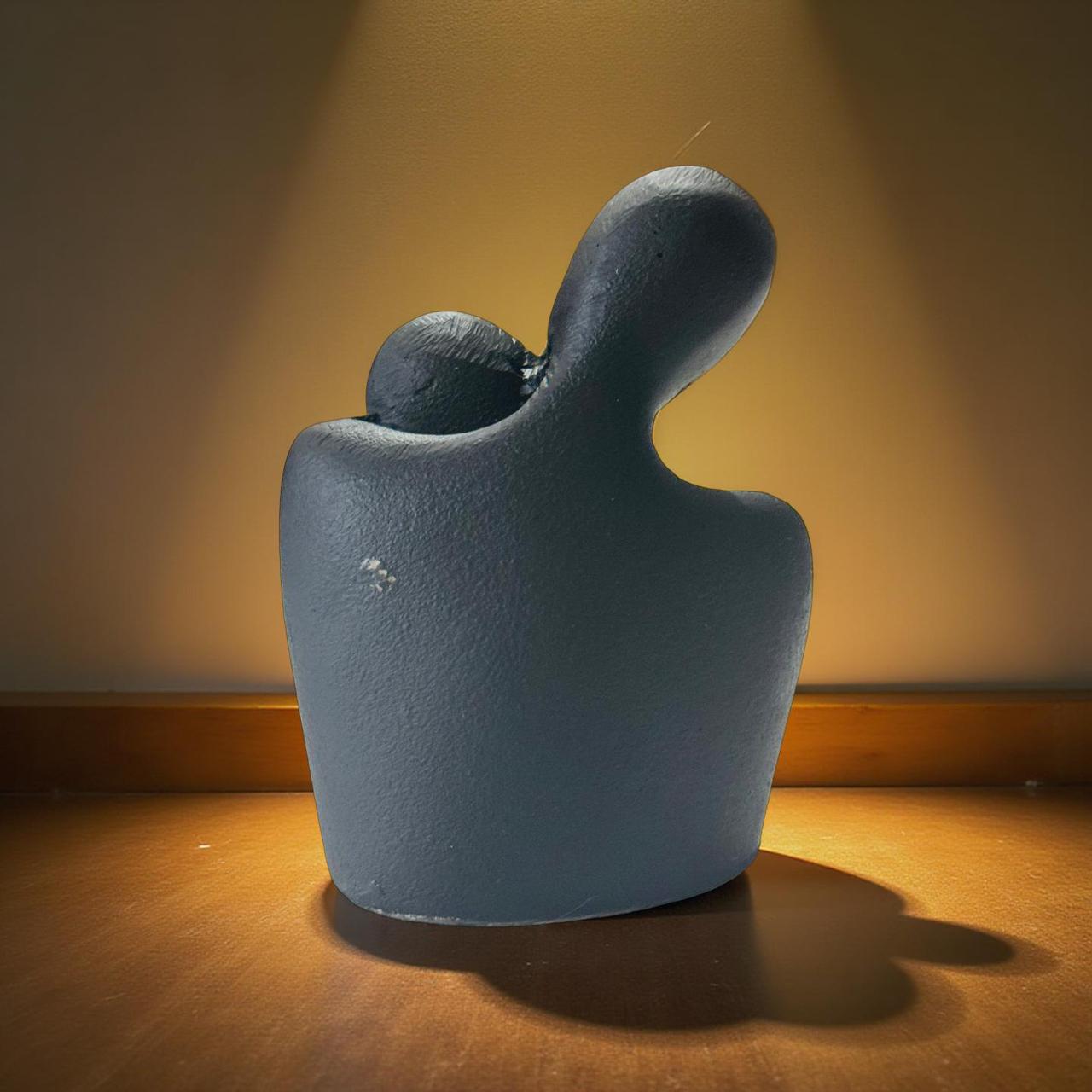 Blue ceramic sculpture on a wooden surface with a warm light background