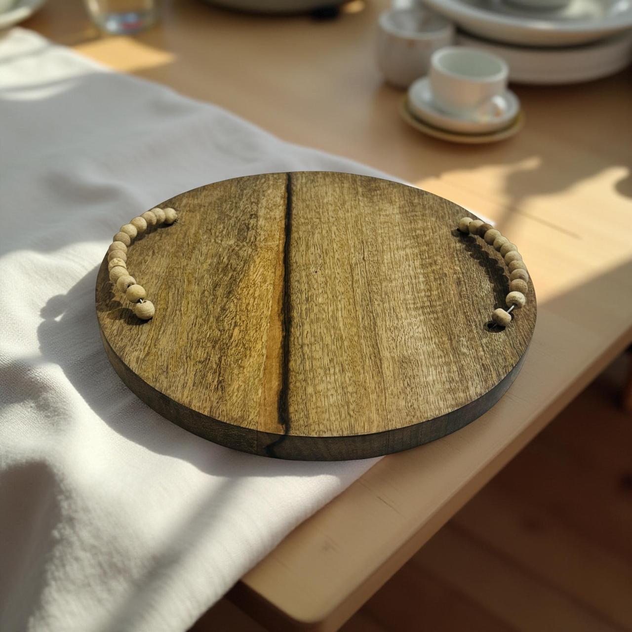 Wooden tray with rope handles on a table with a white cloth
