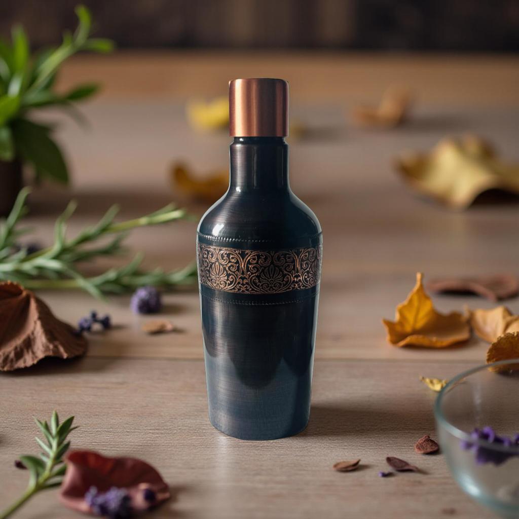 Decorative bottle with intricate design on a wooden surface with leaves and plants.
