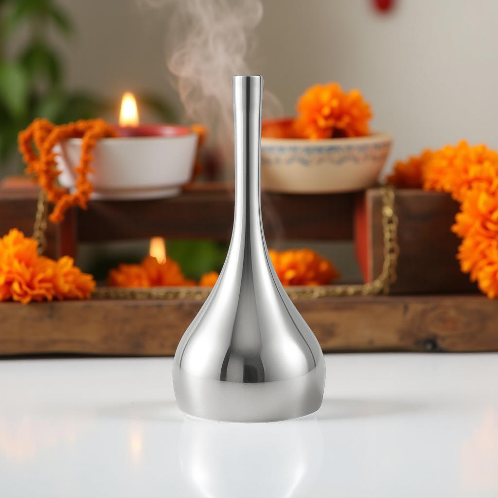 Silver bell with smoke in a decorative setting with flowers and candles.
