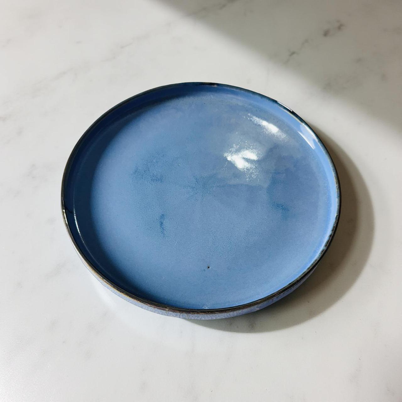 Blue ceramic plate on a white marble surface