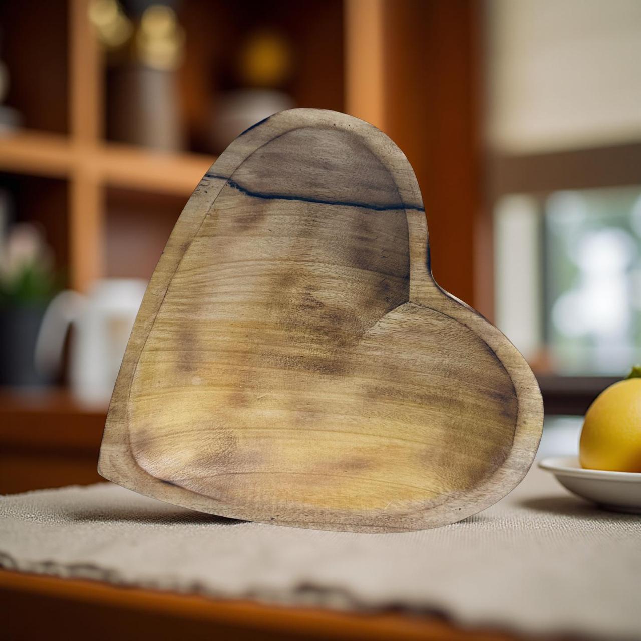Heart-shaped wooden cutting board on a table with a blurred background
