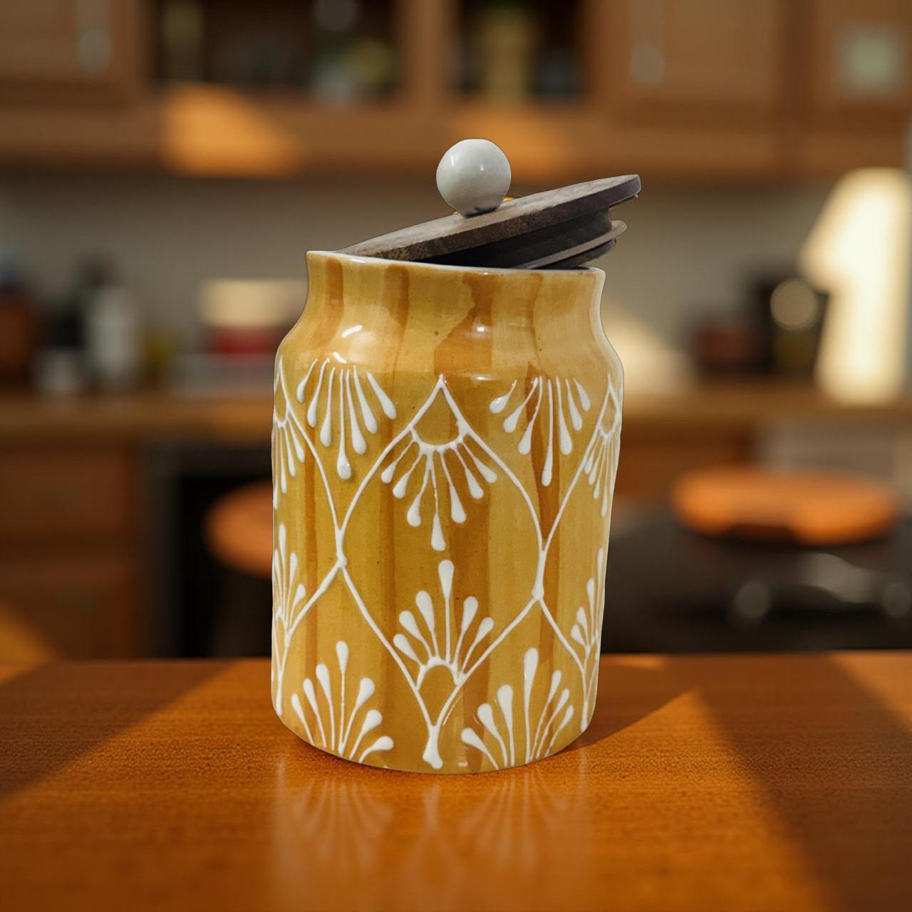 Yellow ceramic jar with white patterns on a wooden surface, blurred kitchen background