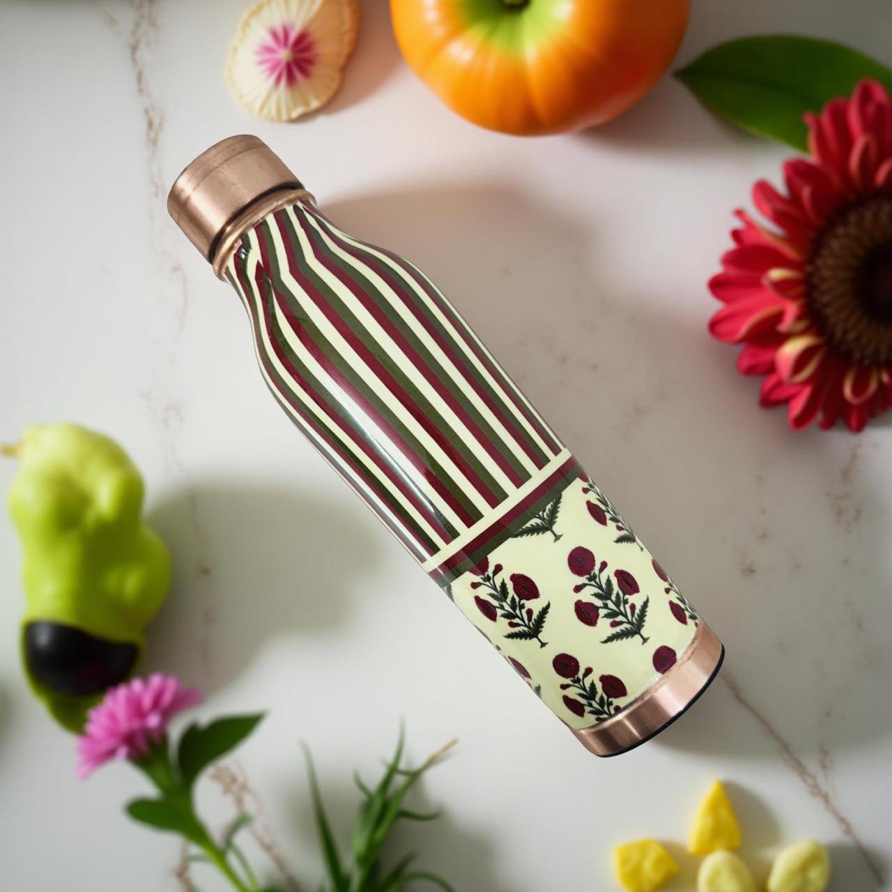 Handcrafted copper water bottle with modern striped and floral print on wooden surface